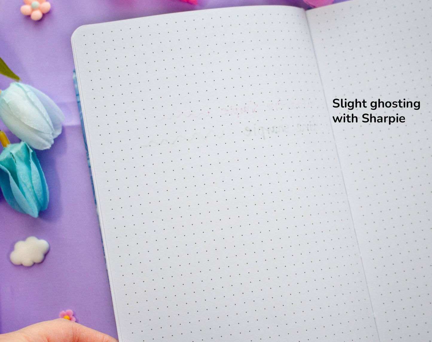 Open notebook with dotted pages and text on a purple background