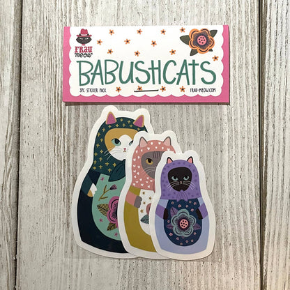 Sticker pack with colorful cat designs on a wooden surface