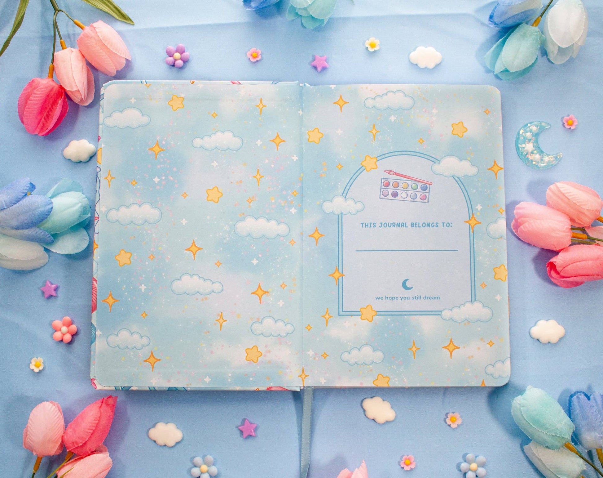 Decorative journal with cloud and star pattern on a blue background with flowers