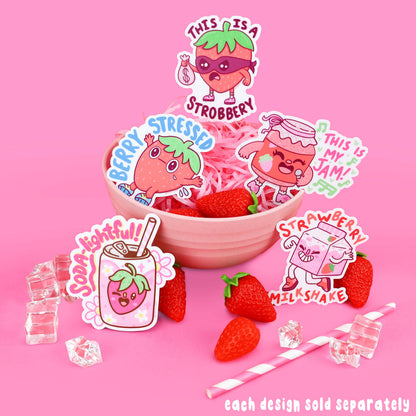 Strawberry character stickers with various expressions and text on a pink background