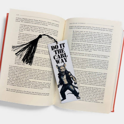 Open book with a bookmark featuring a bear illustration and text on a white background