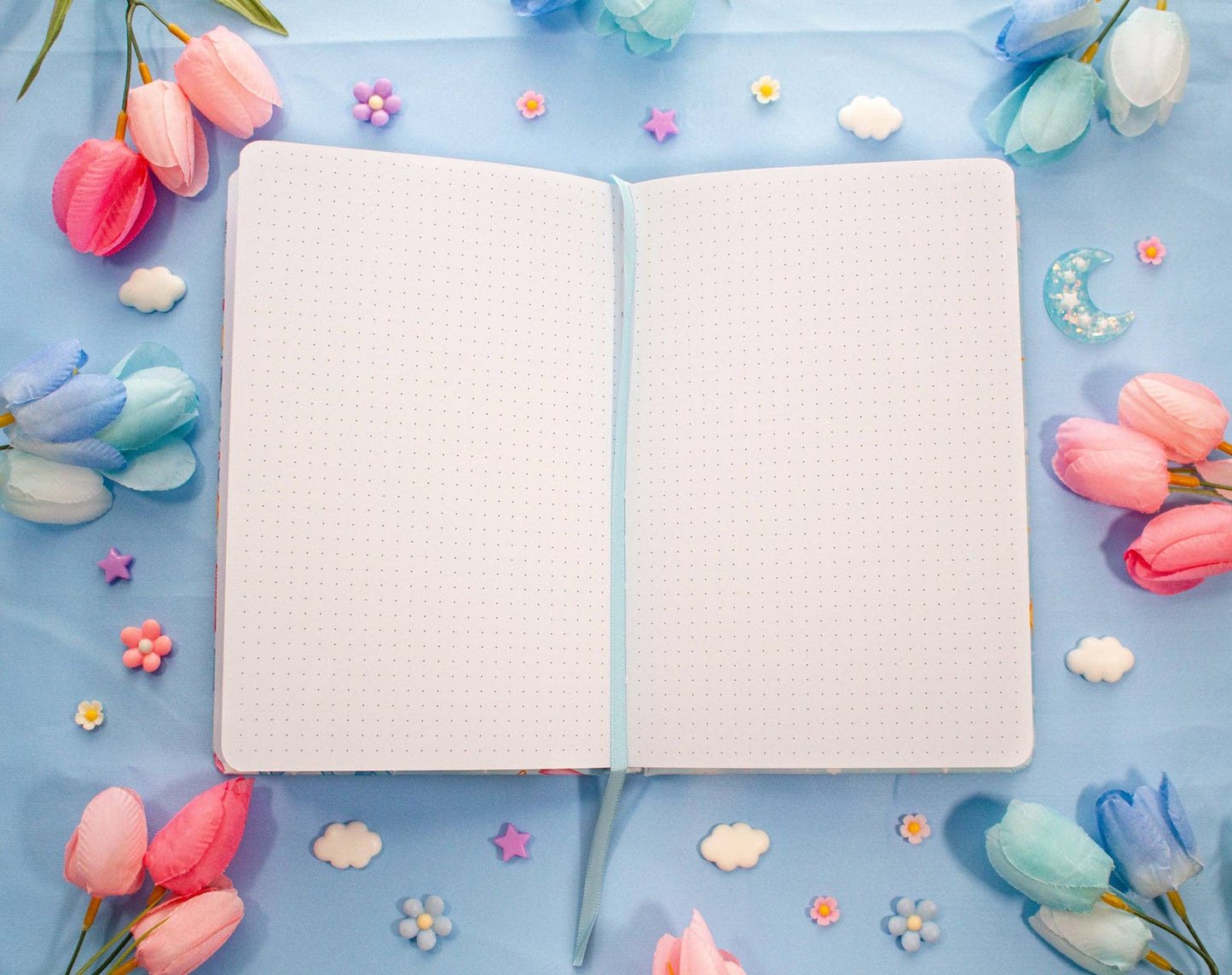 Open notebook on a blue background with pink and blue flowers