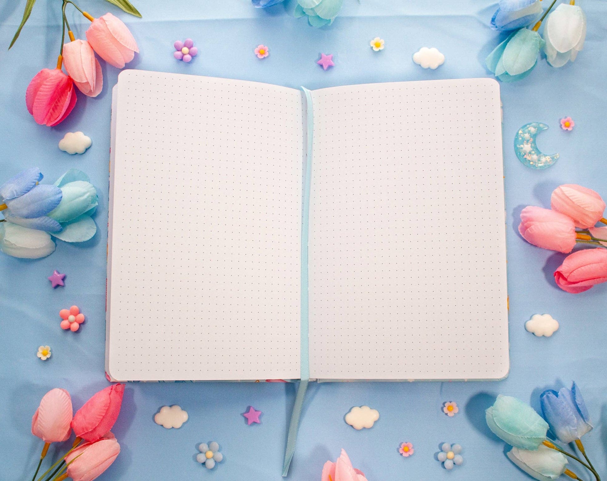 Open notebook on a blue background with pink and blue flowers